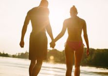 Paar läuft Hand in Hand am Strand entlang