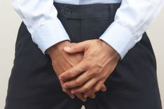 Mann hält die Hände vor seinen Genitalbereich