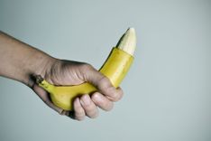 Eine Hand die eine teilweise geschälte Banane hält