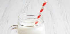 Glas mit Milch, in dem ein Strohhalm steckt