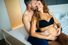Mann umarmt schwangere Frau