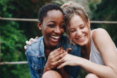 2 Frauen umarmen sich und lachen