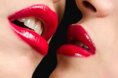 2 Frauen mit rotem Lippenstift sind kurz davor, sich zu küssen
