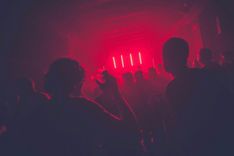 Aufnahme einer Tanzfläche in einem Club, getaucht in rotem Licht.