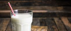 Glas voll Milch, in dem ein Strohhalm steckt