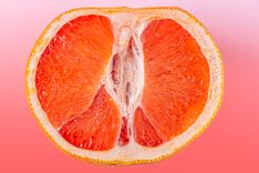Halbierte Orange vor orangenem Hintergund