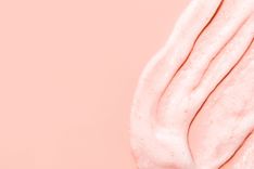 Peeling, das auf der rechten Seite eines pfirsichfarbenen Hintergrunds verteilt ist
