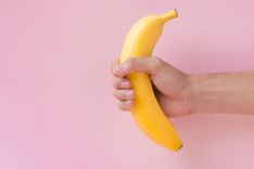 Hand hält eine Banane wie bei einem Handjob