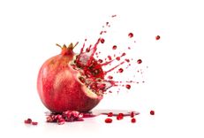 Ein explodierender Granatapfel vor weißem Hintergrund