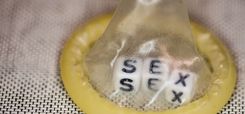 Kondom über Würfeln, die das Wort "Sex" formen
