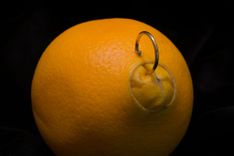 Orange, in der ein Piercing angebracht ist