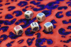 5 Spielwürfel auf einem Leopardenmuster