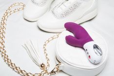 Lila Rabbitvibrator auf einer weißen Handtasche