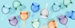 Satisfyer Menstrual Cups auf türkisem Hintergrund