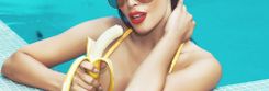 Frau im Pool hält angebissene Banane in der Hand