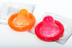 ein rotes und ein orangenes Kondom