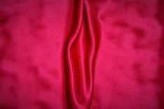 Roter Stoff mit Falten, die wie eine Vulva aussehen