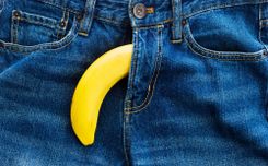 Banane, die auf dem Schlitz einer Jeans schaut