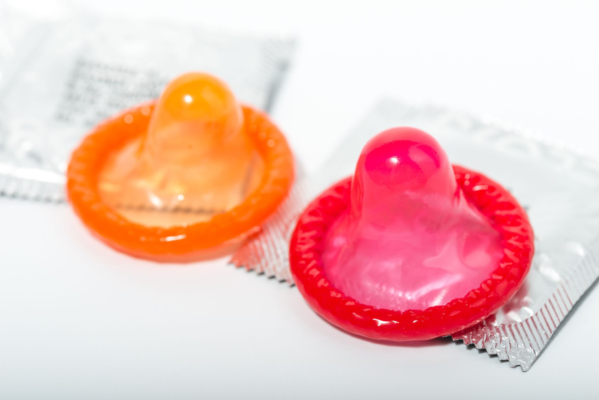 ein rotes und ein orangenes Kondom